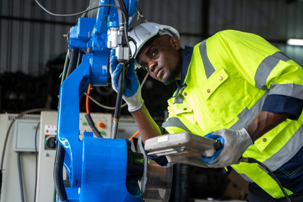 Engineer in modern industrial factory checking and maintain indu